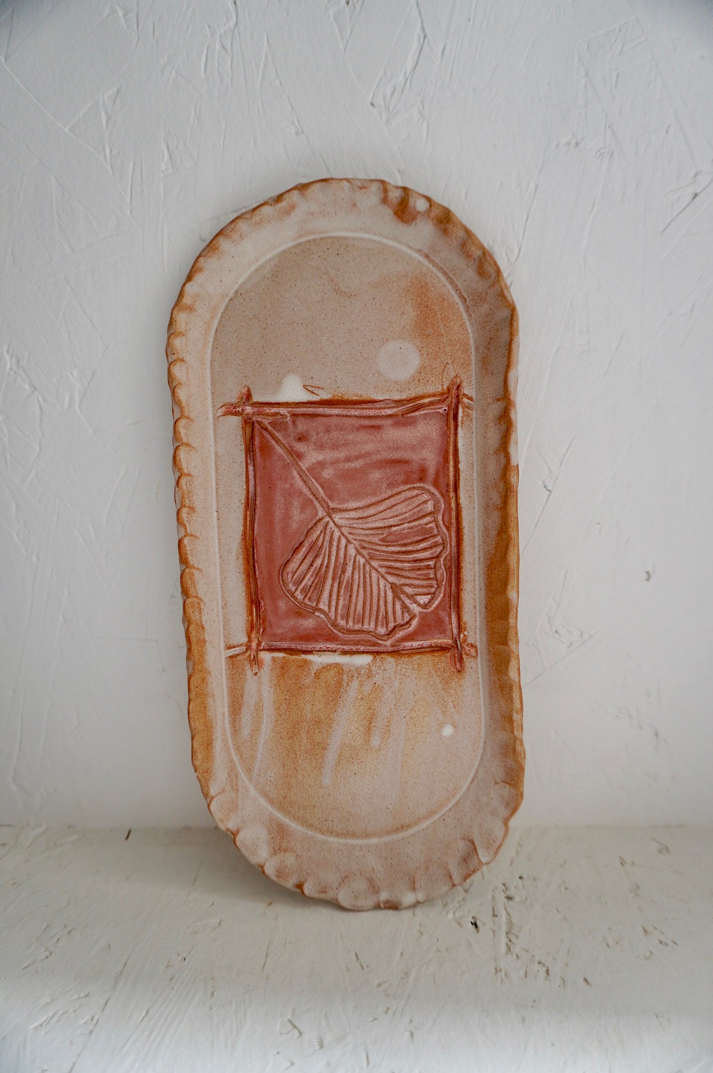 Petit plat de présentation en céramique artisanale avec décor végétal, façonné à la main dans l'atelier Terre NMP à Pau.