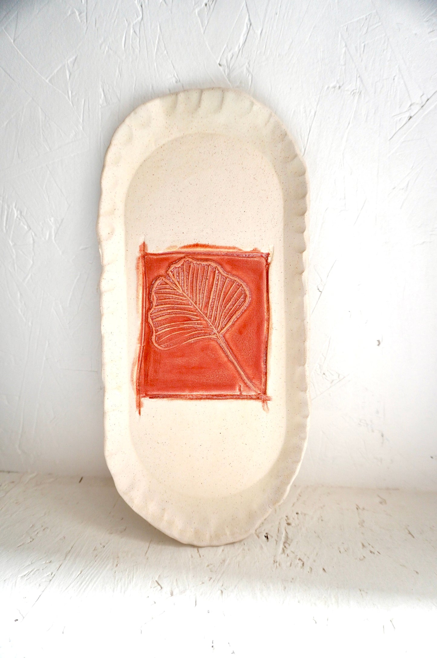 Petit plat de présentation en céramique artisanale avec décor végétal, façonné à la main dans l'atelier Terre NMP à Pau.